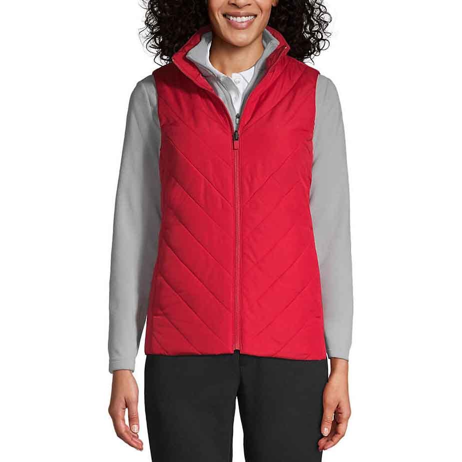 A person is wearing a red zippered quilted vest over a light gray long-sleeve shirt with black pants.