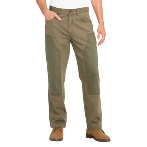 A person is wearing two-tone work pants with reinforced knee patches, paired with brown suede shoes.