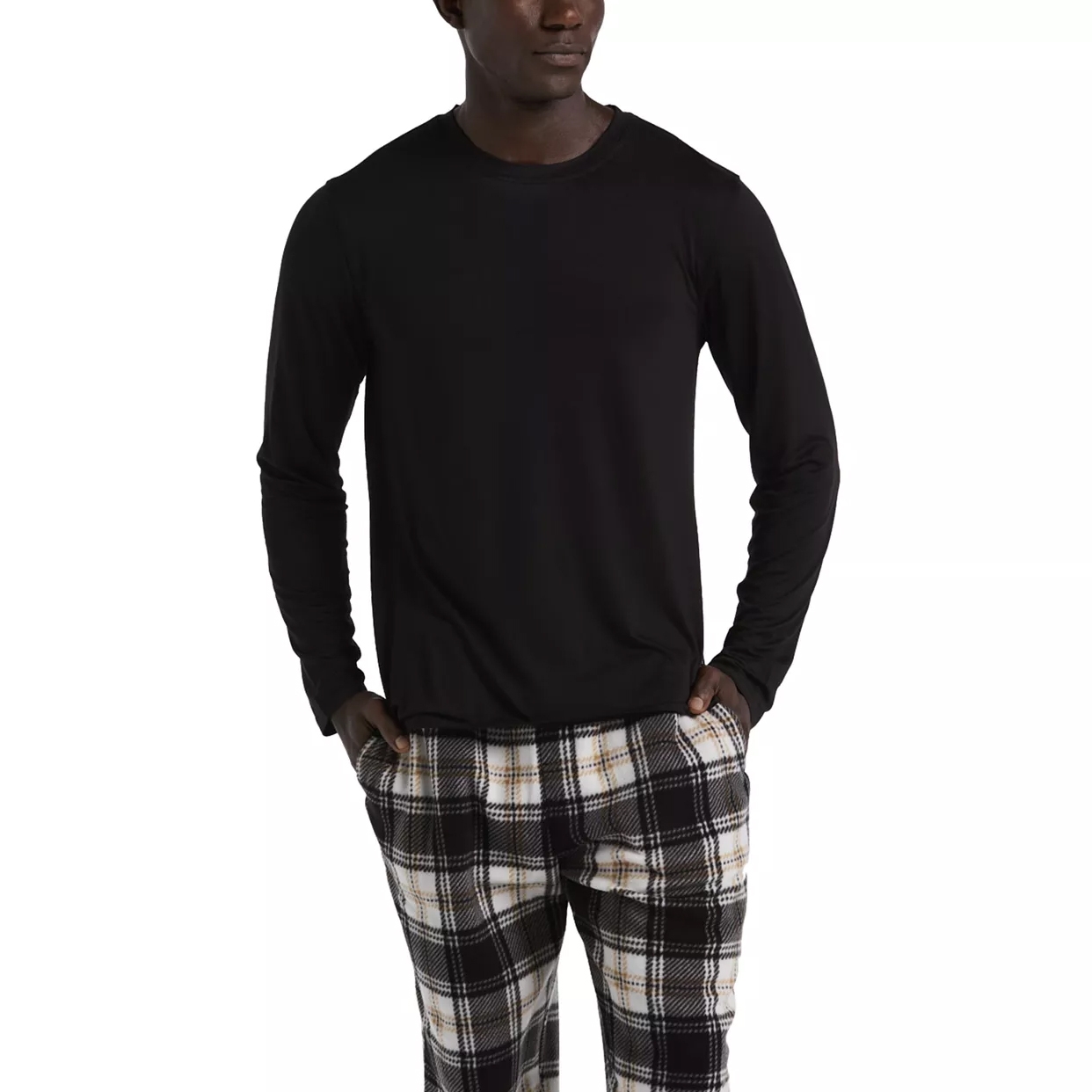 A person is wearing a black long-sleeve shirt paired with black, white, and beige plaid pants.