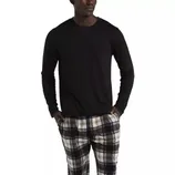 A person is wearing a black long-sleeve shirt paired with black, white, and beige plaid pants.