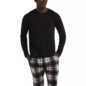 A person is wearing a black long-sleeve shirt paired with black, white, and beige plaid pants.