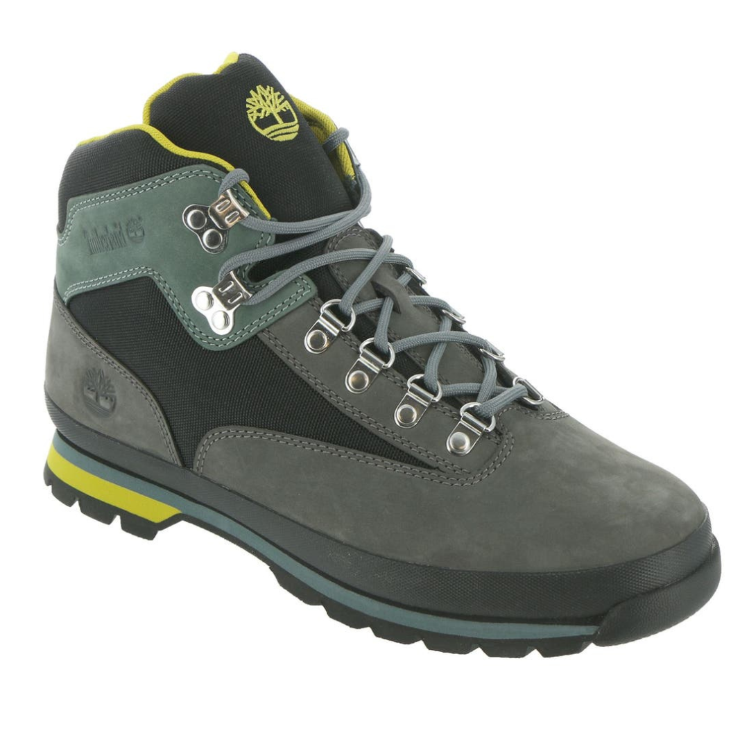 Gray and green hiking boot with yellow accents, featuring metal eyelets and a padded ankle support, branded with the Timberland logo.