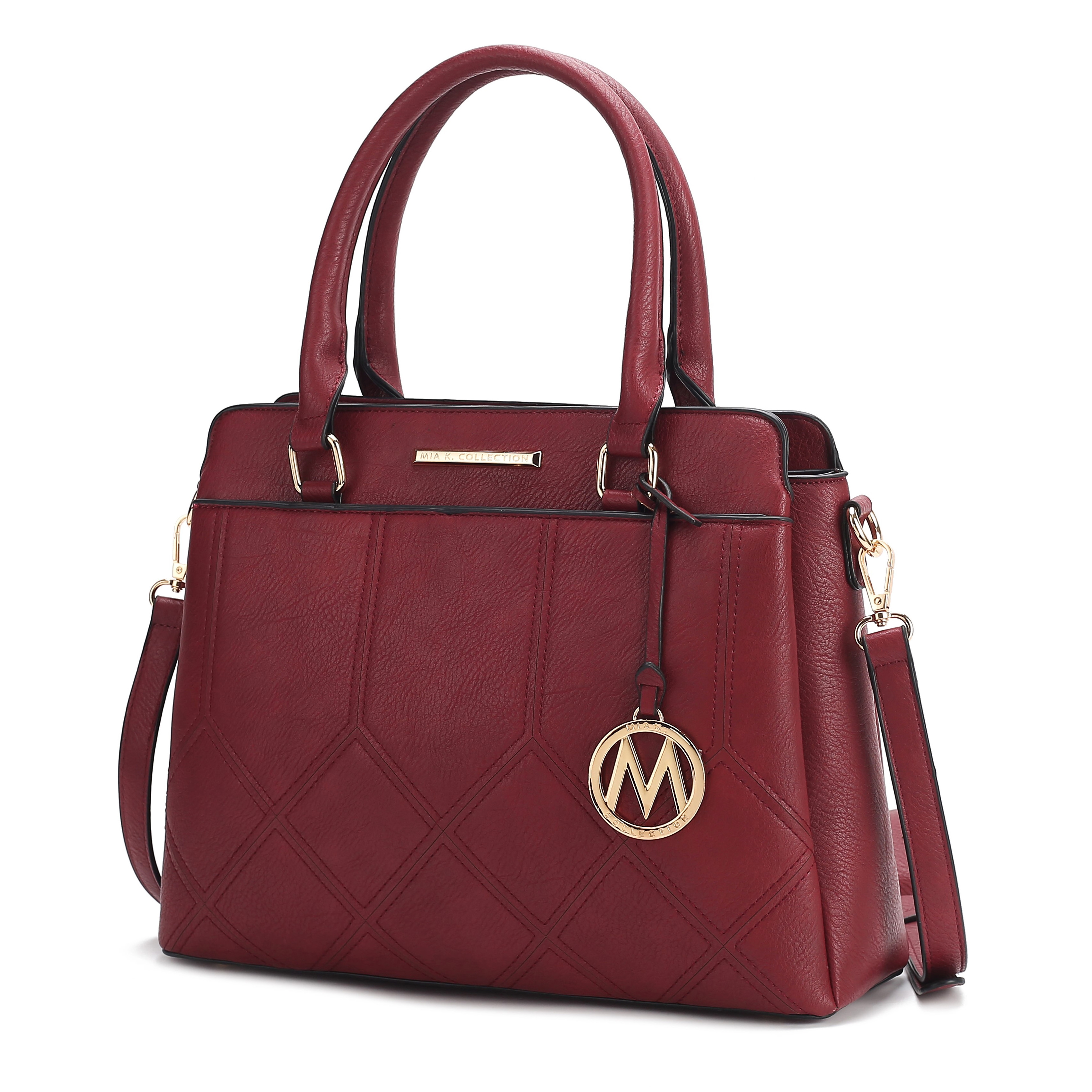 A maroon handbag features quilted detailing, dual handles, and a detachable shoulder strap, embellished with a circular gold charm and logo.