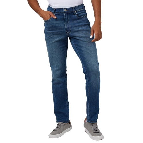 A person wearing blue jeans and gray sneakers.