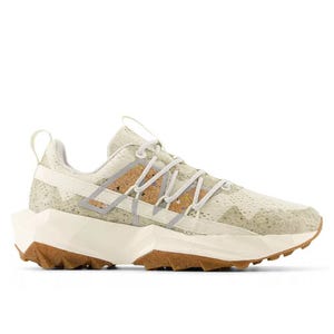 A stylish sneaker with a rugged design, featuring a speckled beige upper, white laces, and a chunky sole with brown accents for added traction.