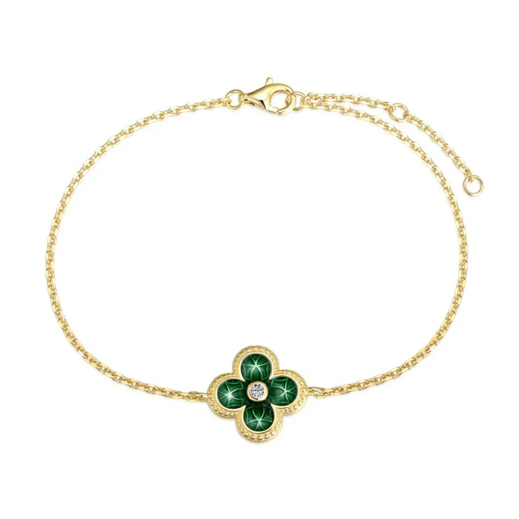 Gold bracelet with a green four-leaf clover design and a central diamond-like stone.
