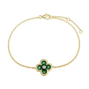 Gold bracelet with a green four-leaf clover design and a central diamond-like stone.