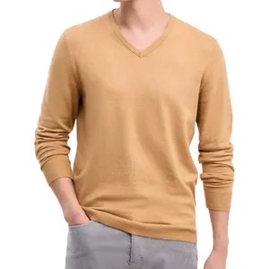 A beige V-neck sweater with long sleeves, paired with light gray pants.
