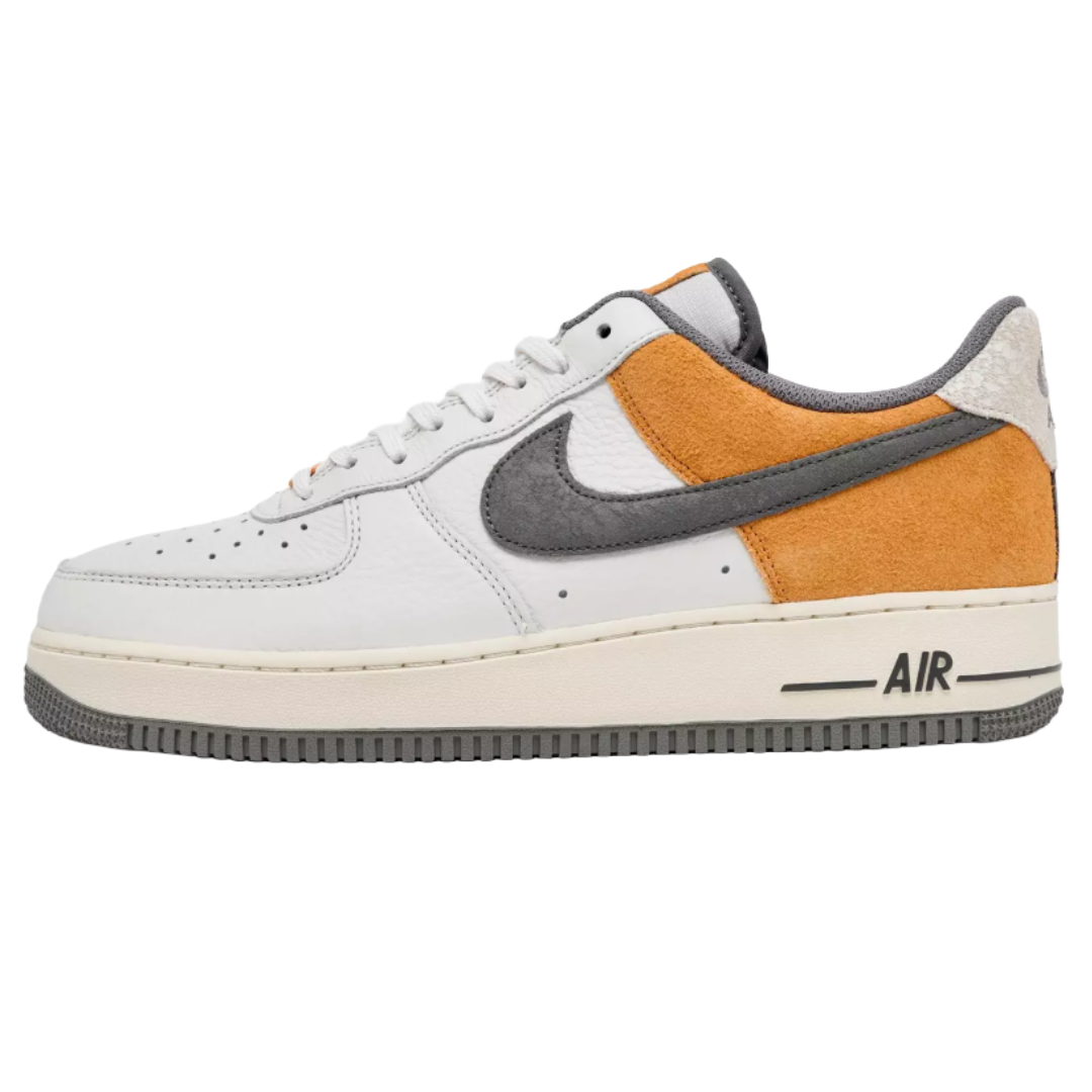 Nike Air Force 1 sneaker featuring white leather, orange suede, and a grey swoosh, with \“AIR\“ branding on the sole.