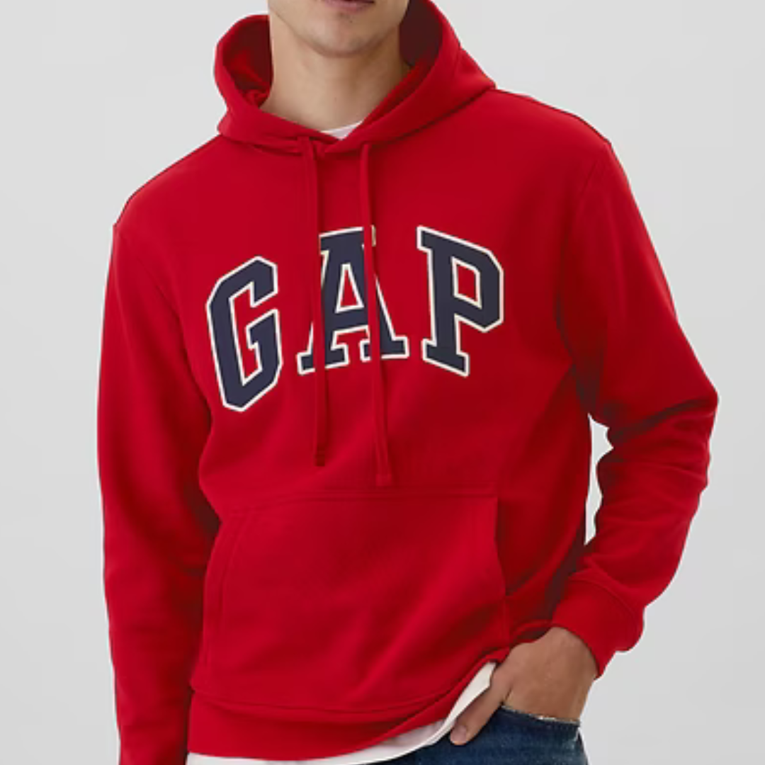 A person wearing a red hoodie with the brand name GAP in large white and navy blue letters across the front.