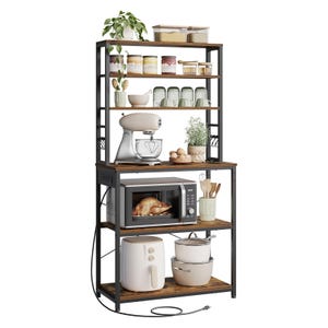 A kitchen rack with four shelves holds a plant, jars, cups, a mixer, eggs, a microwave with a chicken, cooking utensils, an air fryer, and pots.