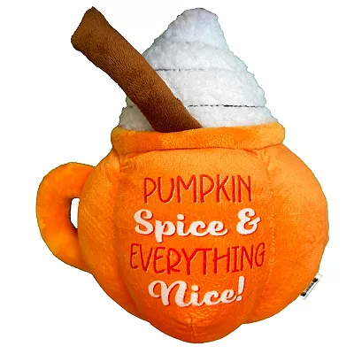 A plush dog toy shaped like an orange pumpkin spice latte mug with \“Pumpkin Spice & Everything Nice!\“ text and a cinnamon stick accent.
