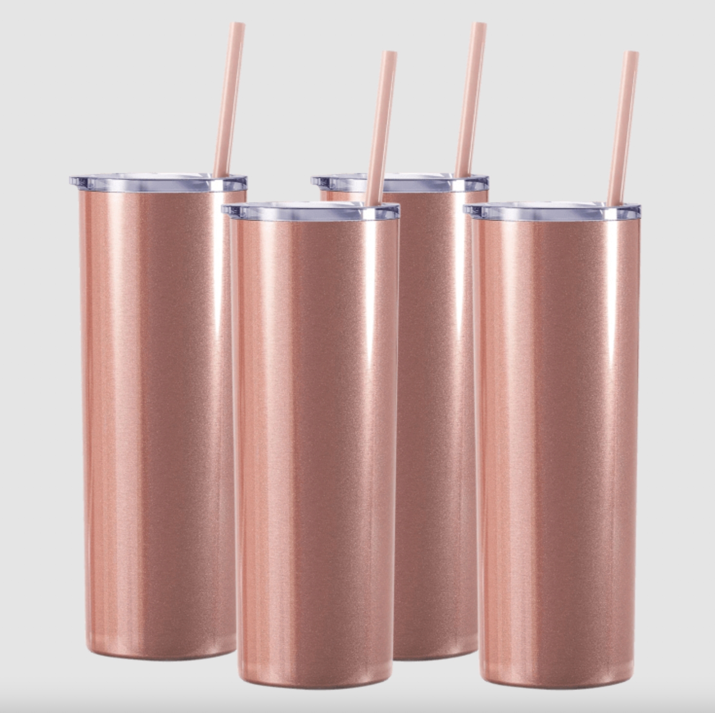 Four identical insulated tumblers with a metallic rose gold finish, each accompanied by a straw and a clear lid.