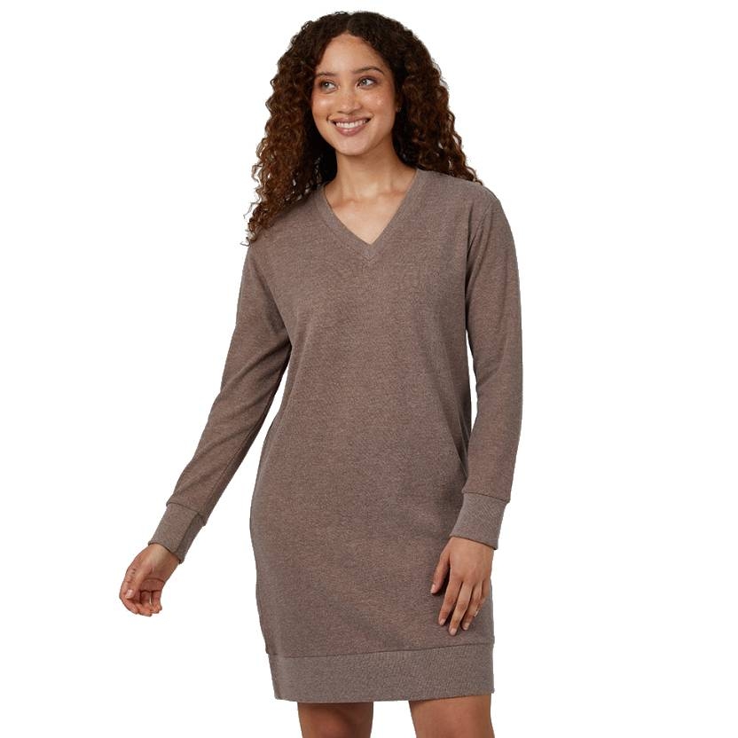A woman is wearing a taupe long-sleeve sweater dress with a V-neck and ribbed cuffs and hem.