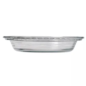 Clear glass pie dish with a decorated rim and horizontally ribbed sides.