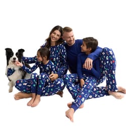 A family of four and a dog are dressed in matching blue pajamas with colorful patterns, showcasing coordinating sleepwear for pets and humans.