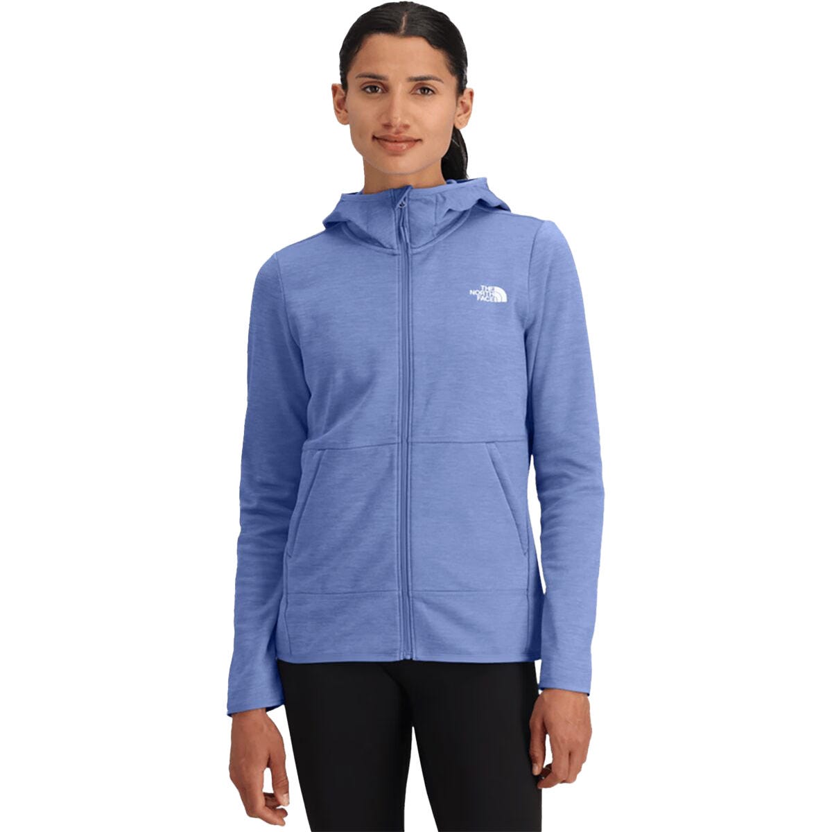 A person wearing a blue North Face hooded zip-up jacket with the logo on the chest, paired with black pants.