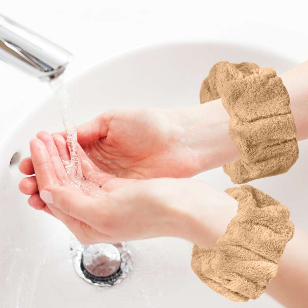 A person washes hands under a tap while wearing tan-colored cuffs designed to prevent water from dripping onto clothes.