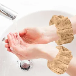 A person washes hands under a tap while wearing tan-colored cuffs designed to prevent water from dripping onto clothes.