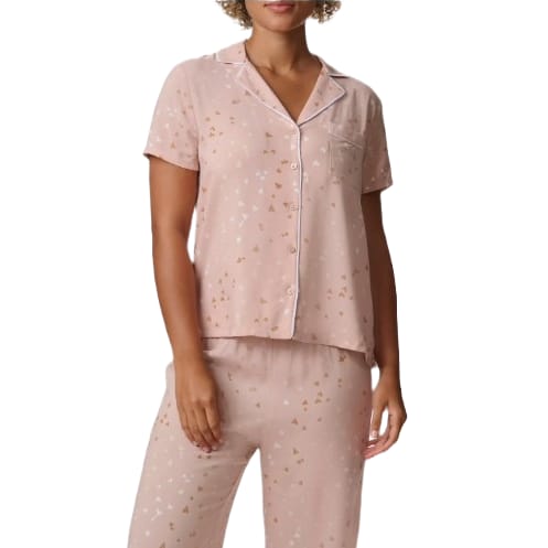 Light pink pajama set with short sleeves and a button-up top featuring white piping and small silver and gold geometric shapes scattered throughout.