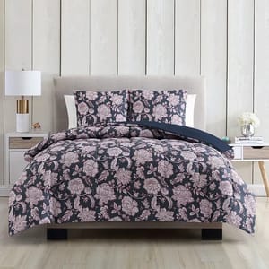 A bed with floral-patterned bedding set including a duvet cover and pillows.