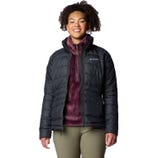 A woman is wearing a black Columbia brand insulated jacket with a maroon underlayer and olive green pants.