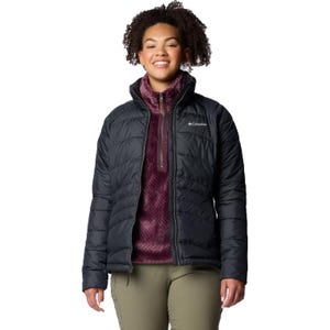 A woman is wearing a black Columbia brand insulated jacket with a maroon underlayer and olive green pants.