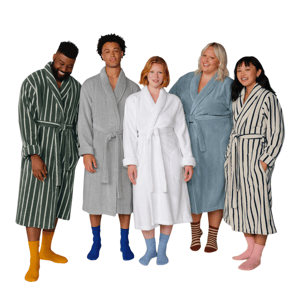 Five diverse individuals wearing different colored and patterned bathrobes, each paired with colorful socks, standing in a row.