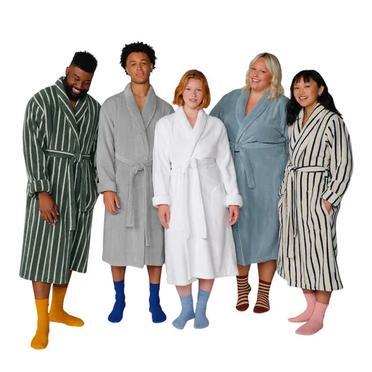 Five diverse individuals wearing different colored and patterned bathrobes, each paired with colorful socks, standing in a row.
