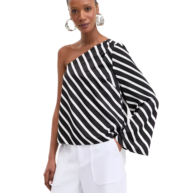A black-and-white, one-shoulder top with diagonal stripes and a long, wide sleeve, paired with white pants.