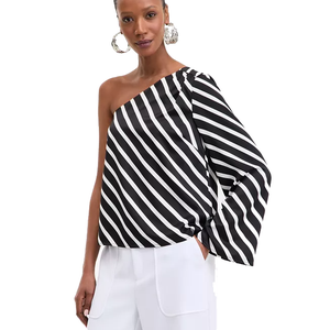 A black-and-white, one-shoulder top with diagonal stripes and a long, wide sleeve, paired with white pants.