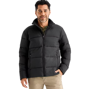 A man is wearing a black puffer jacket with a front zipper and side pockets, paired with beige pants.