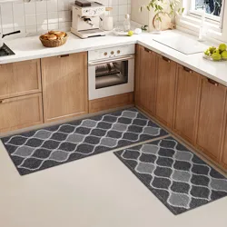 Two gray kitchen rugs with a geometric pattern are placed on the floor in front of wooden cabinets and a white countertop.
