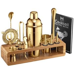 Gold cocktail shaker set with various bar tools, including a shaker, strainer, muddler, jigger, and a recipe book, all housed in a wooden stand.