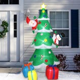 An inflatable outdoor Christmas tree stands at 8 feet tall, featuring a snowman and Santa Claus climbing it, with colorful wrapped gift boxes at its base.