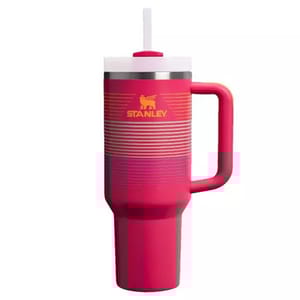 A red Stanley travel mug with a handle and straw, featuring a stainless steel accent near the lid.