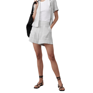 Gray and white striped linen-blend shorts with a relaxed fit, featuring an elastic waistband and side pockets, paired with a matching short-sleeve shirt and black strappy sandals.