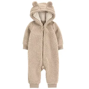 A beige, fluffy infant onesie with a hood and bear ears, featuring a front zipper and ribbed cuffs at the wrists and ankles.