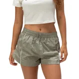 A woman wearing a white Nike crop top and olive-green drawstring shorts with side pockets. The shorts have white piping along the sides.