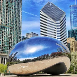 A reflective bean-shaped sculpture known as \“Cloud Gate\“ is set against a background of modern skyscrapers in Chicago.