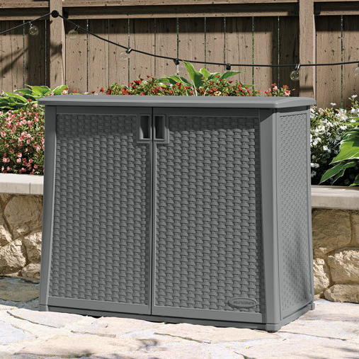 A gray resin outdoor storage cabinet with rattan pattern and a planter on top.