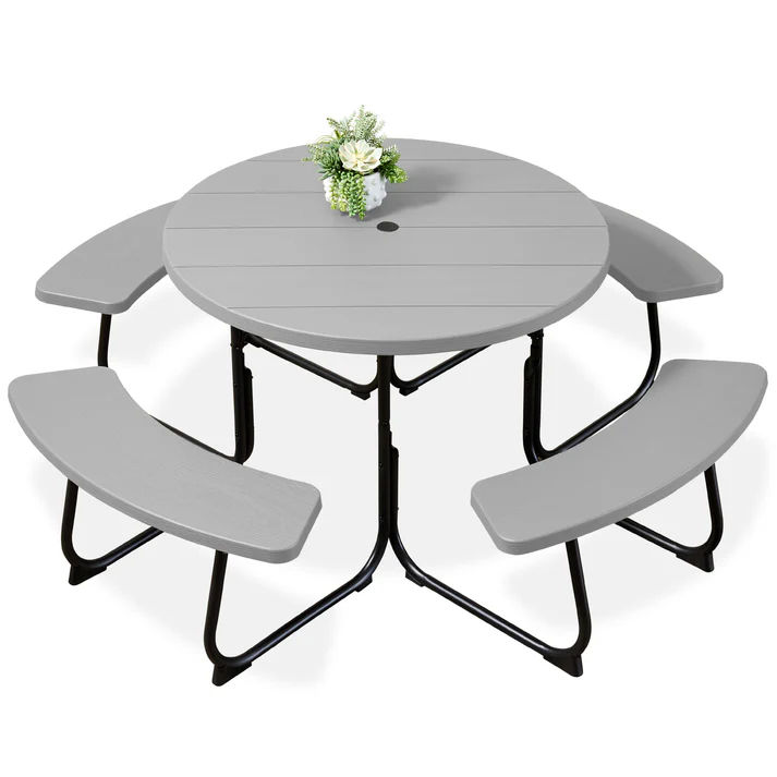 Round gray picnic table with three attached curved benches, supported by black steel legs; features a small bouquet in the center and a hole for an umbrella.