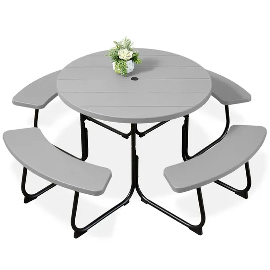 Round gray picnic table with three attached curved benches, supported by black steel legs; features a small bouquet in the center and a hole for an umbrella.