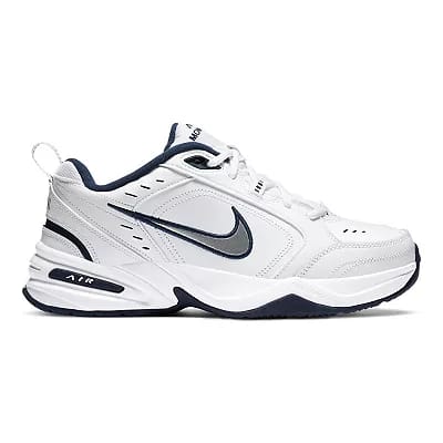 White Nike Air Monarch IV sneakers with navy accents and a bold black Nike swoosh on the side.