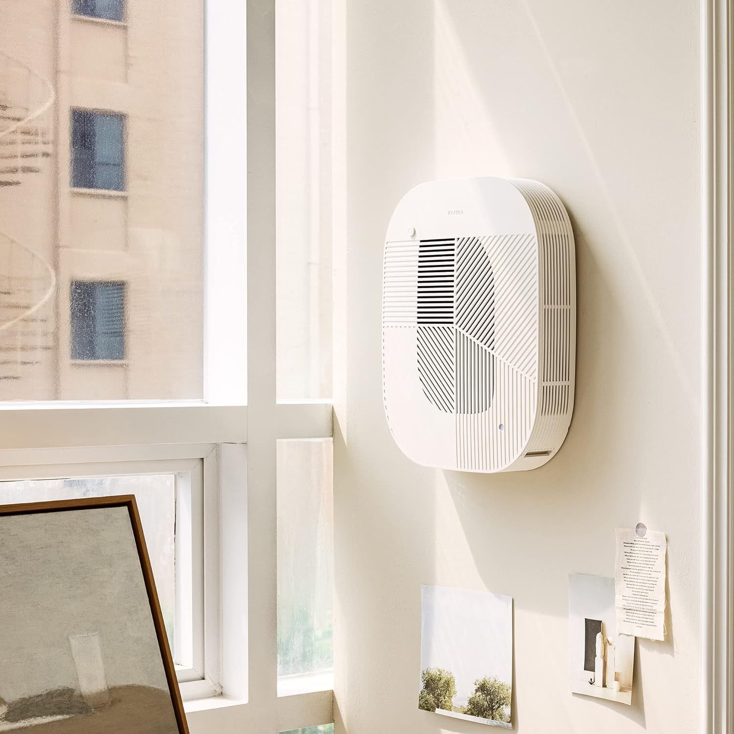 Wall-mounted air purifier next to a window.