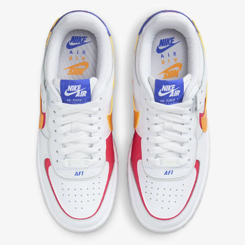 A pair of Nike Air Force 1 sneakers in white, with red and yellow accents, viewed from above.