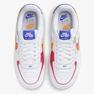 A pair of Nike Air Force 1 sneakers in white, with red and yellow accents, viewed from above.