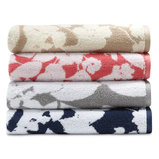 Four rolled towels with abstract floral patterns in beige, coral, gray, and navy.