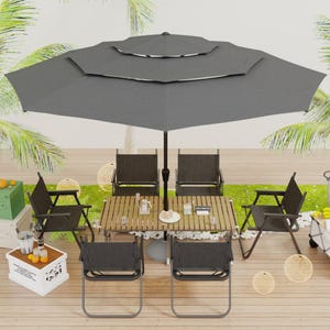 A patio setup featuring a large dark gray umbrella, wooden table, and six matching chairs with metal frames, surrounded by tropical decor and plants, with additional items like a cooler, drinks, and fruit nearby.
