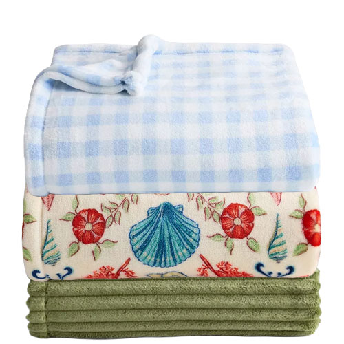 Three folded blankets: a blue and white checkered one, a floral one with seashell and flower patterns, and a plain green one.